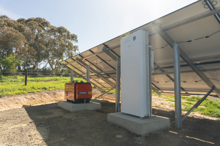 Off-grid battery and automatic-start generator installed beneath a ground-mounted solar array at Mount Jagged, South Australia